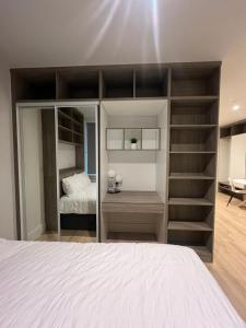 Habitación con 1 cama y 1 dormitorio con estanterías. en London Heathrow Airport Apartment Voyager House Terminal 12345 - EV Electric and Parking available! en New Bedfont