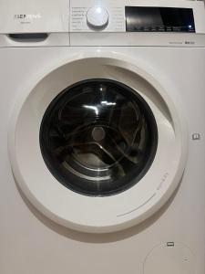 a close up of a white washing machine at London Heathrow Airport Apartment Voyager House Terminal 12345 - EV Electric and Parking available! in New Bedfont