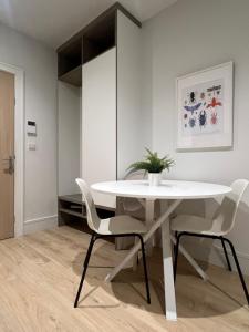 a dining room with a white table and chairs at London Heathrow Airport Apartment Voyager House Terminal 12345 - EV Electric and Parking available! in New Bedfont