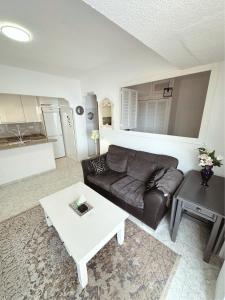uma sala de estar com um sofá e uma mesa em Apartamentos del Fuerte Marbella - Centro y Playa em Marbella