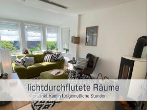uma sala de estar com um sofá verde e uma cadeira em Ferienhaus Dackelglück em Schmallenberg