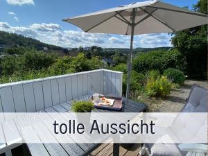 einen Tisch mit einem Regenschirm und einem Teller Essen drauf. in der Unterkunft Ferienhaus Dackelglück in Schmallenberg
