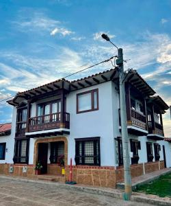 Casa blanca con balcones y luz de la calle en Casa Akuaina en Villa de Leyva