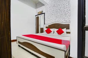 1 dormitorio con 1 cama grande con almohadas rojas en OYO Flagship Hotel Vivek Plaza en Ambāla