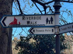 a street sign that reads riverside walk and a thames park at Chic Battersea Retreat in London