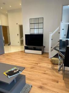 a living room with a flat screen tv on a table at Chic Battersea Retreat in London