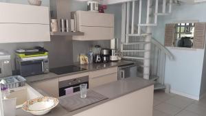 a kitchen with white cabinets and a counter top at Duplex bord de mer in Terre-de-Haut