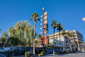 una señal de hotel frente a un edificio con palmeras en Oasis at Gold Spike - Adults Only, en Las Vegas