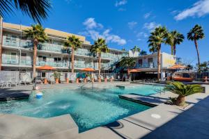 a swimming pool in front of a hotel with palm trees at Oasis at Gold Spike - Adults Only in Las Vegas