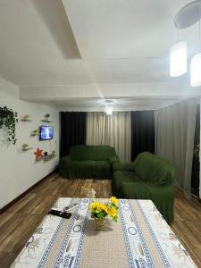 a living room with a green couch and a table at Casa de praia 2 quartos, 2 banheiros, 1 lavabo, sala, cozinha, Estacionamento para dois carros e a 300m da praia in Angra dos Reis