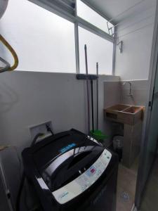 a bathroom with a tv in a room with a sink at Aparta-estudio completo en Itagüí - 501 in Itagüí