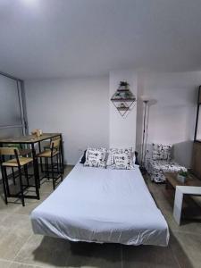 a bedroom with a large white bed and a table at Aparta-estudio completo en Itagüí - 501 in Itagüí