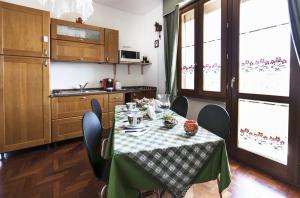 une cuisine avec une table et un tissu de table vert et blanc dans l'établissement Sa Mariposa, à Ittiri