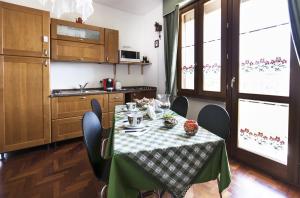 a kitchen with a table with a green and white table cloth at Sa Mariposa in Ittiri