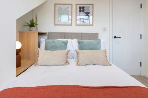 a bedroom with a large white bed with pillows at Raincliffe Nook by NordStay in Knowsthorpe