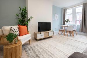 a living room with a couch and a tv and a table at Raincliffe Nook by NordStay in Knowsthorpe