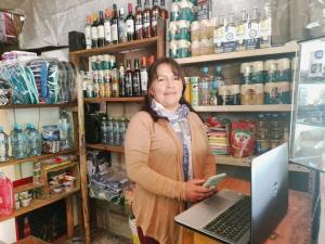 a woman standing in a store with a laptop computer at HOSTEL SAMANA WASI CHAULLAY in Cusco