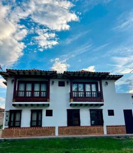 Casa blanca con ventanas y cielo azul en Casa Akuaina en Villa de Leyva