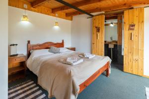 a bedroom with a bed with two towels on it at Piuke Mapu Patagonia Hostel in Cholila