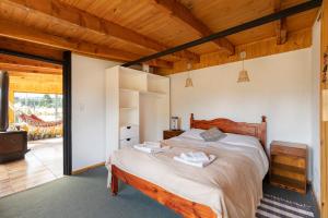 1 dormitorio con 1 cama grande en una habitación en Piuke Mapu Patagonia Hostel en Cholila