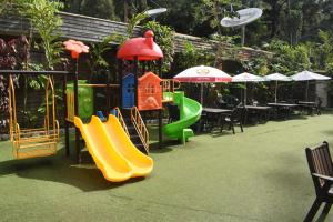 a playground with slides and tables and umbrellas at Pacific Gardens Hotel in Goroka