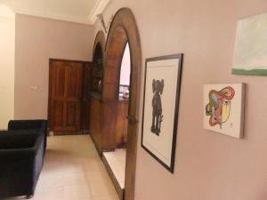 un pasillo con un espejo en la pared y un sofá negro en Templar's court, en Port Harcourt