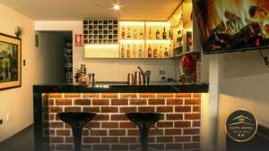 un bar con dos taburetes frente a una pared de ladrillo en YURAQ WASI Hotel/Restobar, en Huánuco