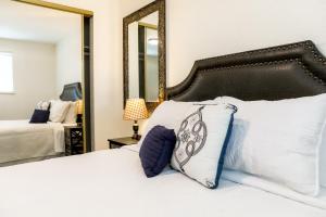 1 dormitorio con cama blanca y espejo en Quiet Kennewick Condos en Kennewick