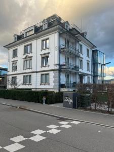 een wit gebouw aan de kant van een straat bij Lakeview House in Horgen +7 foto's