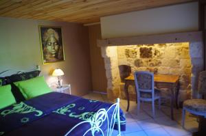 ein Schlafzimmer mit einem Bett und einem Tisch und Stühlen in der Unterkunft Ndila Cottage piscine privée in Fatouville-Grestain