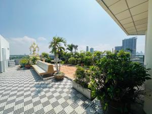 The most prosperous seaside seaview apartment in Jomtien(Tub, high speed Wi-Fi, Projector) في جومتين بيتش: شرفة مع مقاعد ونباتات على مبنى