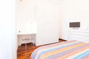 Habitación blanca con cama y escritorio en Semplicemente Casa, en Milán