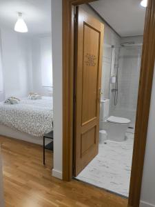 drzwi prowadzące do sypialni z łóżkiem i łazienką w obiekcie LA VAGUADA w mieście Zamora