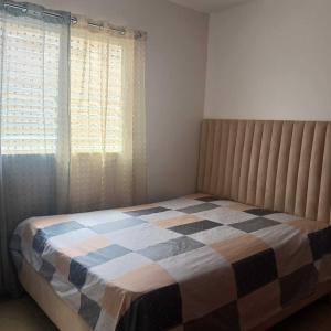 1 dormitorio con 1 cama con manta a cuadros en Ocean Breeze Apartment in La Romana, en La Romana