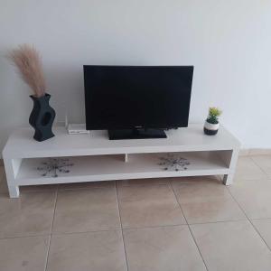 a white entertainment center with a flat screen tv on it at Ocean Breeze Apartment in La Romana in La Romana
