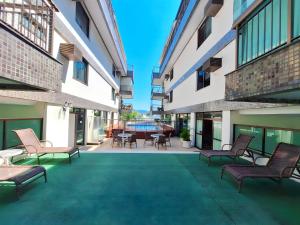 a courtyard with chairs and a table in a building at Camboinhas Inn in Niterói