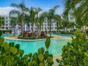 a resort swimming pool with palm trees and a building at 1Bed/1Bath Pet Friendly Condo at the Melia in Orlando