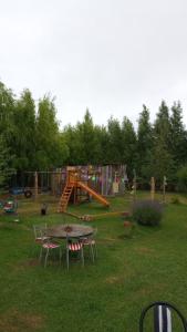 un parque con mesa, sillas y parque infantil en Los cardones, en Gobernador Gregores