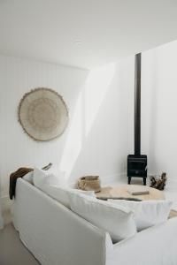 a living room with white walls and a white couch at Salt at Shoal Bay in Shoal Bay