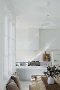 a kitchen with white counters and a stove top oven at Salt at Shoal Bay in Shoal Bay