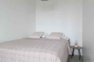 a white bedroom with a bed and a table at City Apartment Pankkitalo in Kuopio