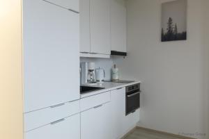 a white kitchen with white cabinets and appliances at City Apartment Pankkitalo in Kuopio
