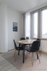 a table and chairs in a room with windows at City Apartment Pankkitalo in Kuopio