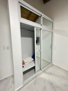 a large glass cabinet in a white room at Richie’s House En Licey Al Medio in Santiago de los Caballeros