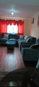 a living room with couches and a red curtain at Mi casa tu casa. My house in La Paz