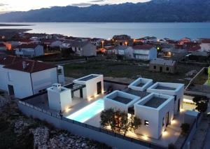 une villa avec une piscine la nuit dans l'établissement Designer Villa Neva With Magic Velebit View, à Ražanac