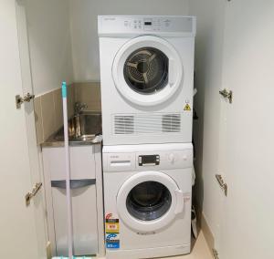 a washing machine and a washer in a small room at High-Rise on Collins with Free Parking, Pool, Gym in Melbourne
