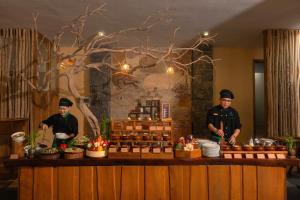 zwei Köche stehen vor einer Theke mit Essen in der Unterkunft Green Bay Phu Quoc Resort & Spa in Phu Quoc + 37 Fotos