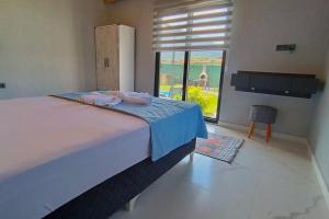 1 dormitorio con cama grande y ventana grande en Villa Mucize, en Fethiye