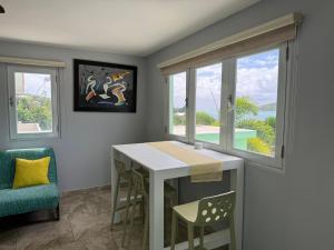 a dining room with a table and two windows at Villa Ensenada Honda in Culebra